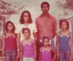 Op deze gezinsfoto ista ik met mijn ouders en zussen. Ik ben degene met een blauw vestje (Suriname, 1975). Privé collectie. 